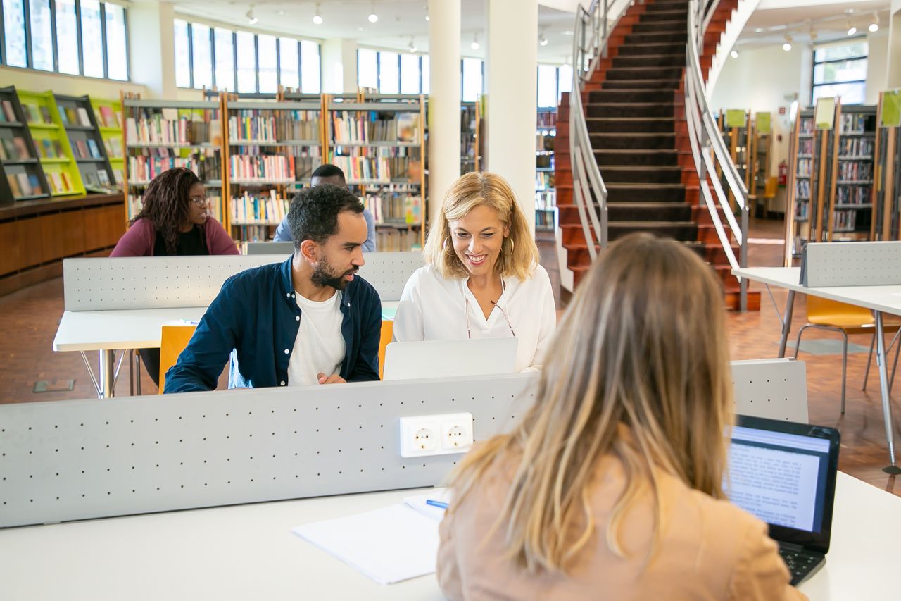 Groupe d'étudiants étudiant ensemble dans une bibliothèque universitaire